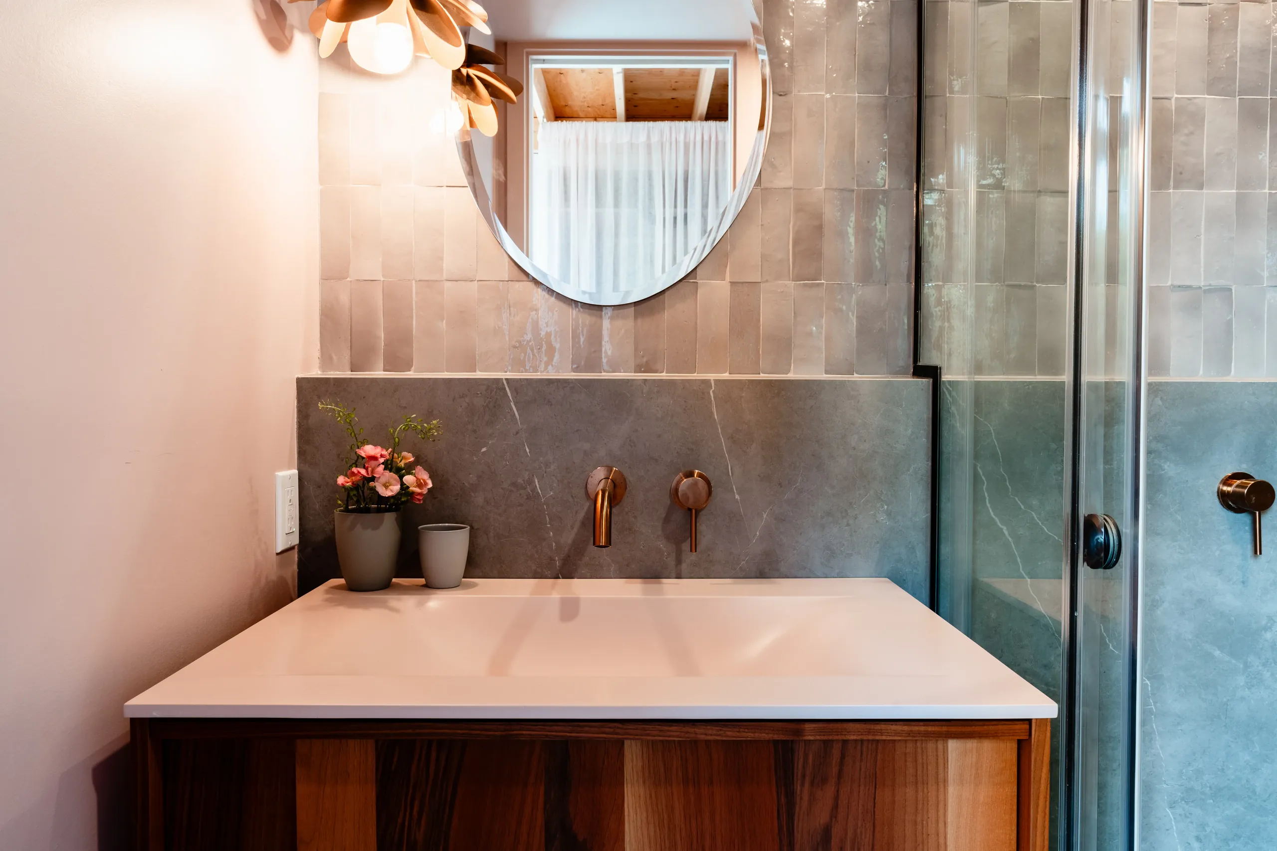 Salle de bain d'invités avec vanité en chêne chaleureux et comptoir en pierre adoucie — chalet des Laurentides.
