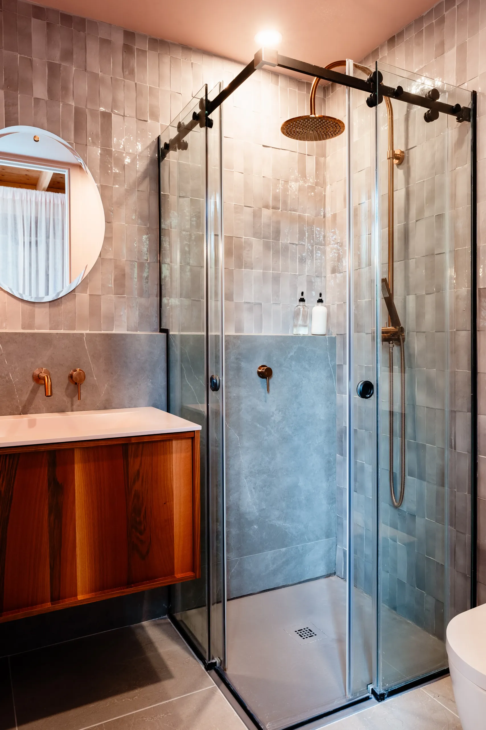 Détail de la salle de bain d'invités — robinetterie en noir mat sur palette de pierre discrète, chalet à Mont-Tremblant.