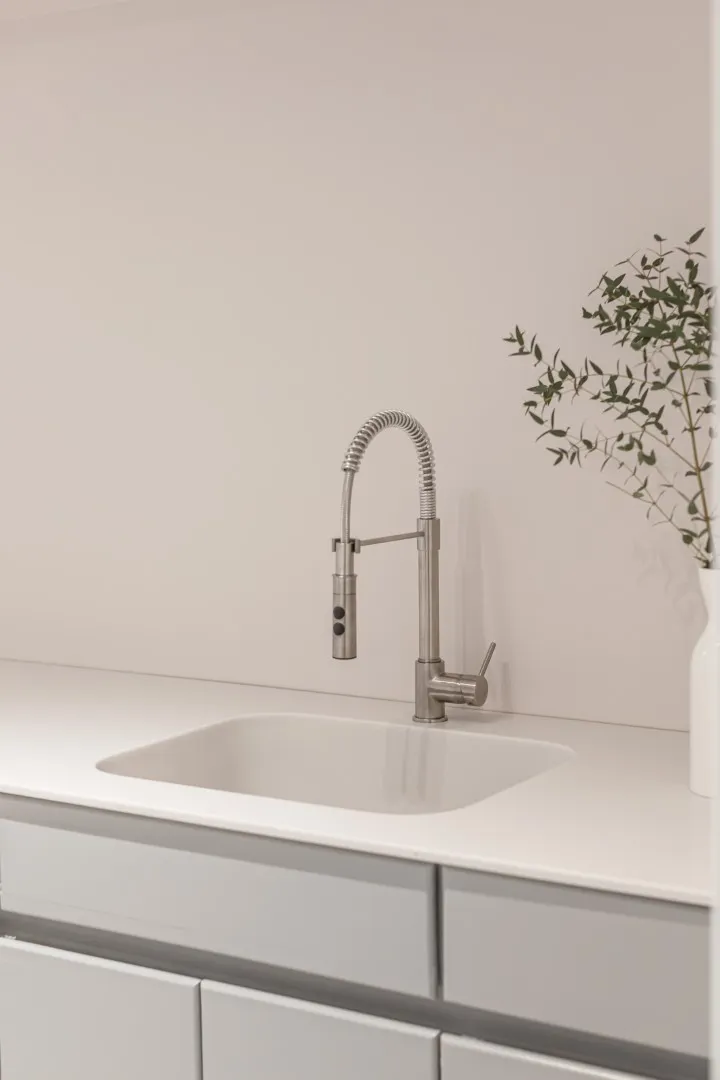 Salle de lavage du bungalow de Montréal — rangements dissimulés derrière une ébénisterie sur mesure.