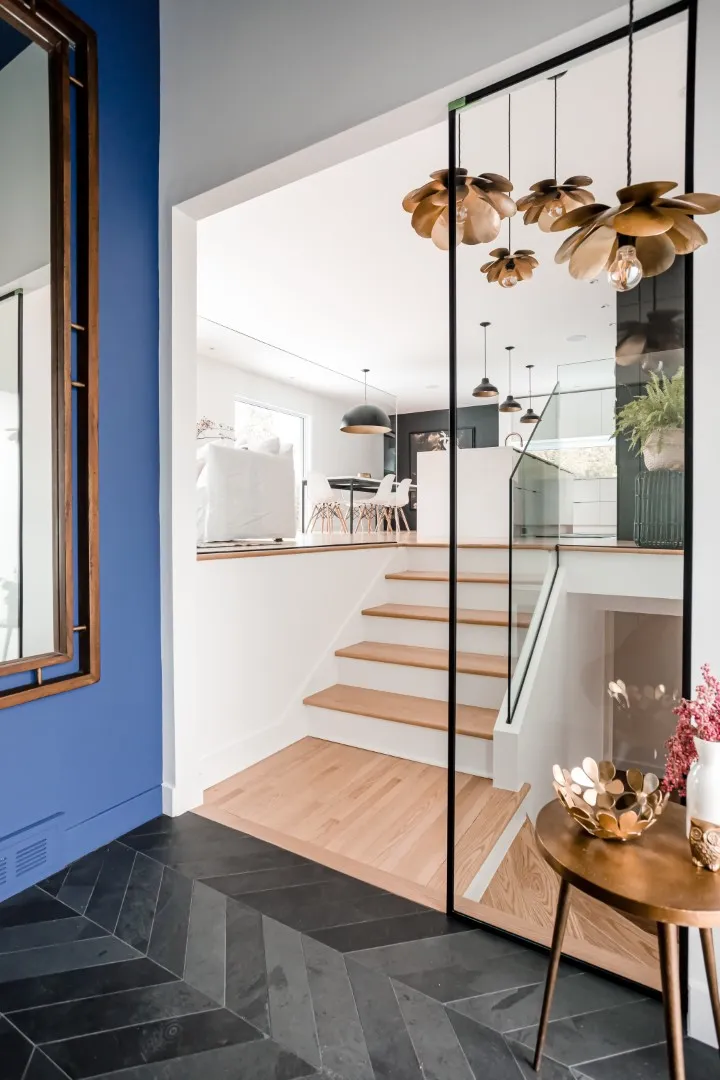 Détail du vestibule dans le bungalow de Montréal — chêne naturel et murs d'un blanc doux.