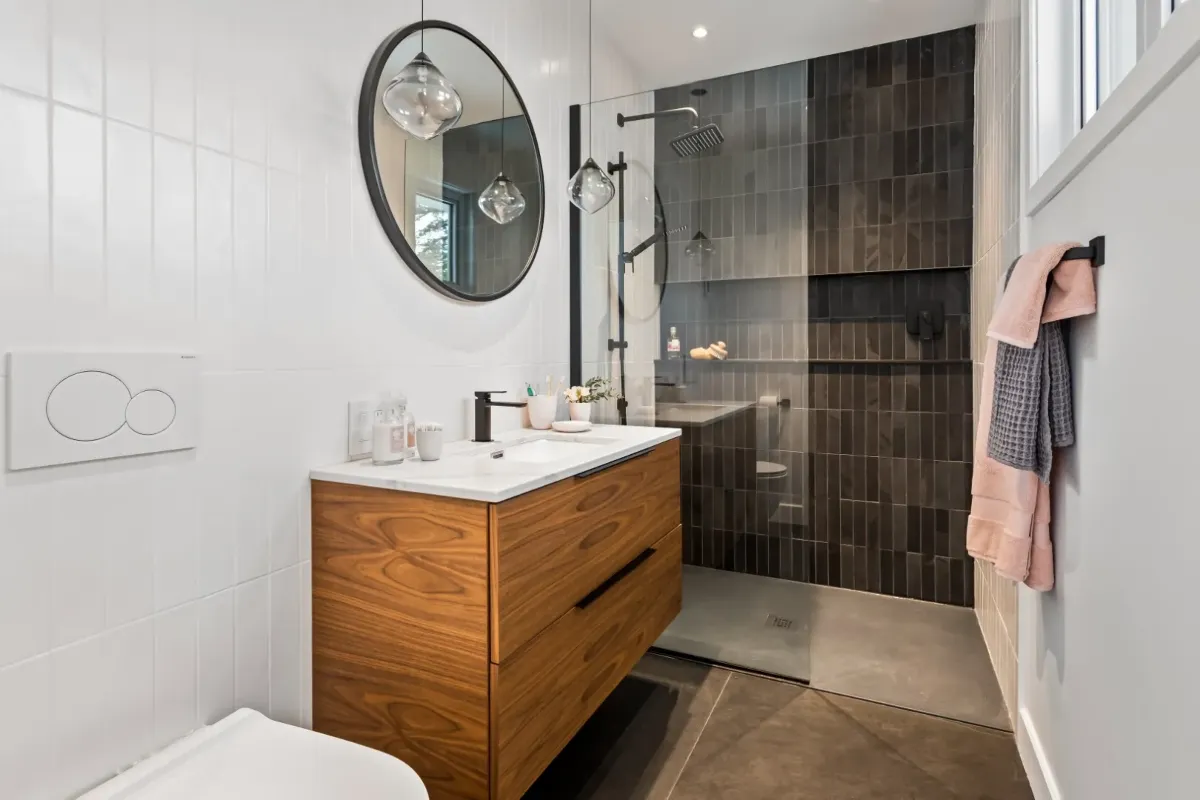 Salle de bain principale du bungalow de Montréal — baignoire autoportante adossée à un pan de mur en céramique.