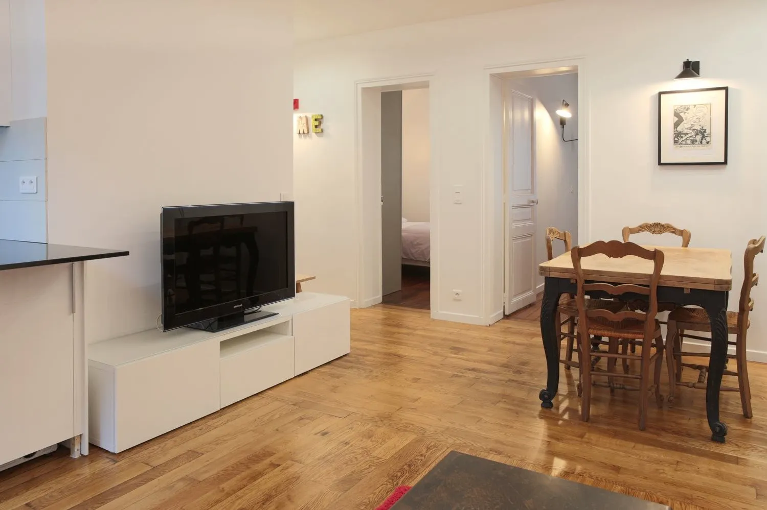 Dining corner in the Paris 16e rental — provincial table on refreshed oak floor.